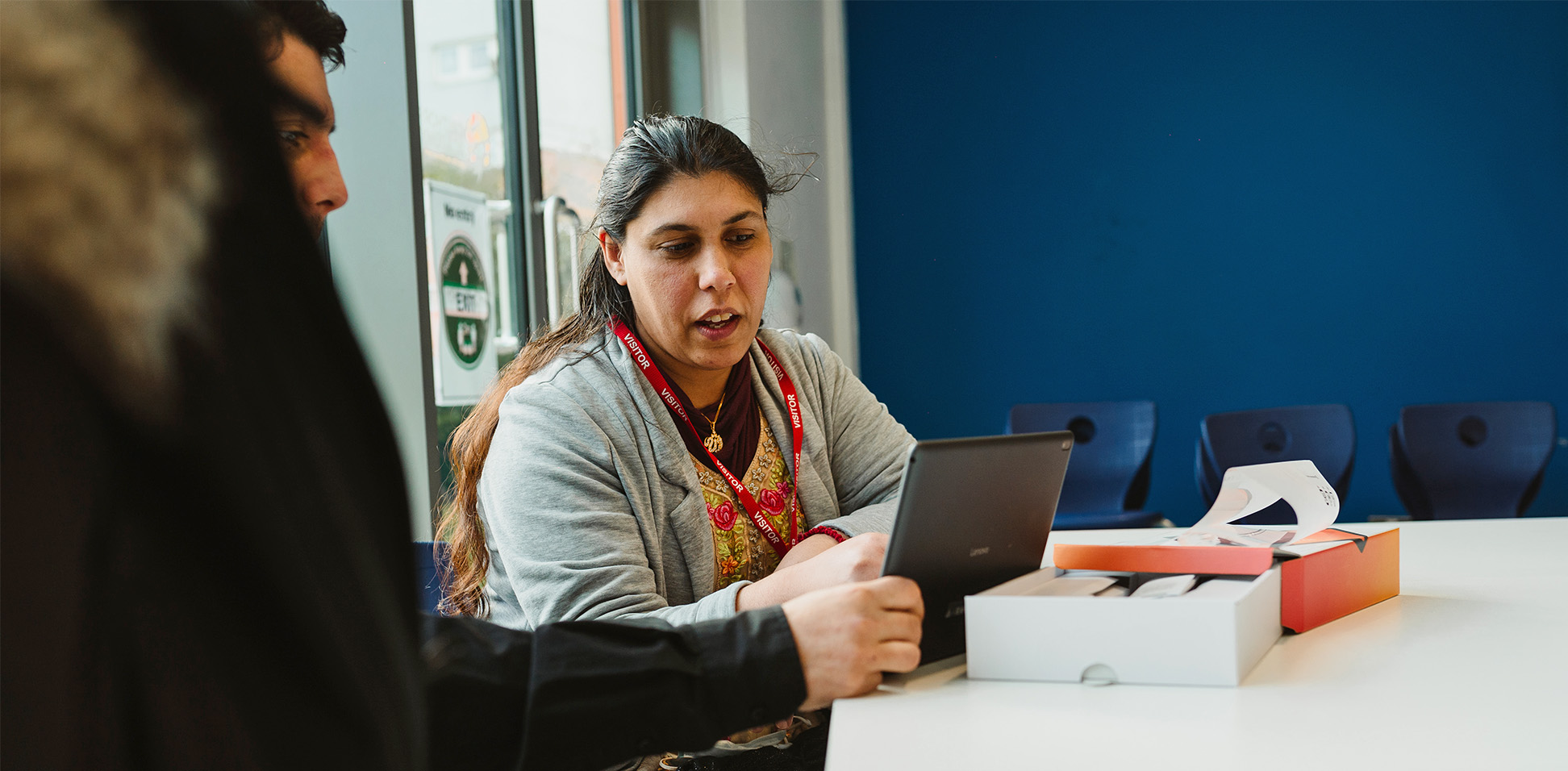 A woman helps a man setup a donated tablet from the National Device Bank