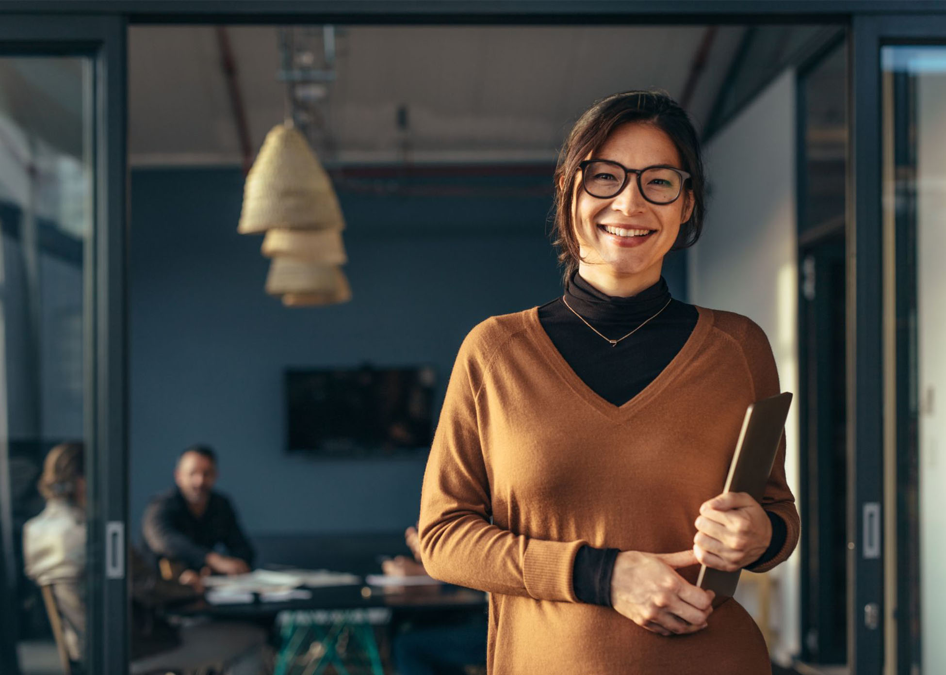 A woman holding a laptop in an office