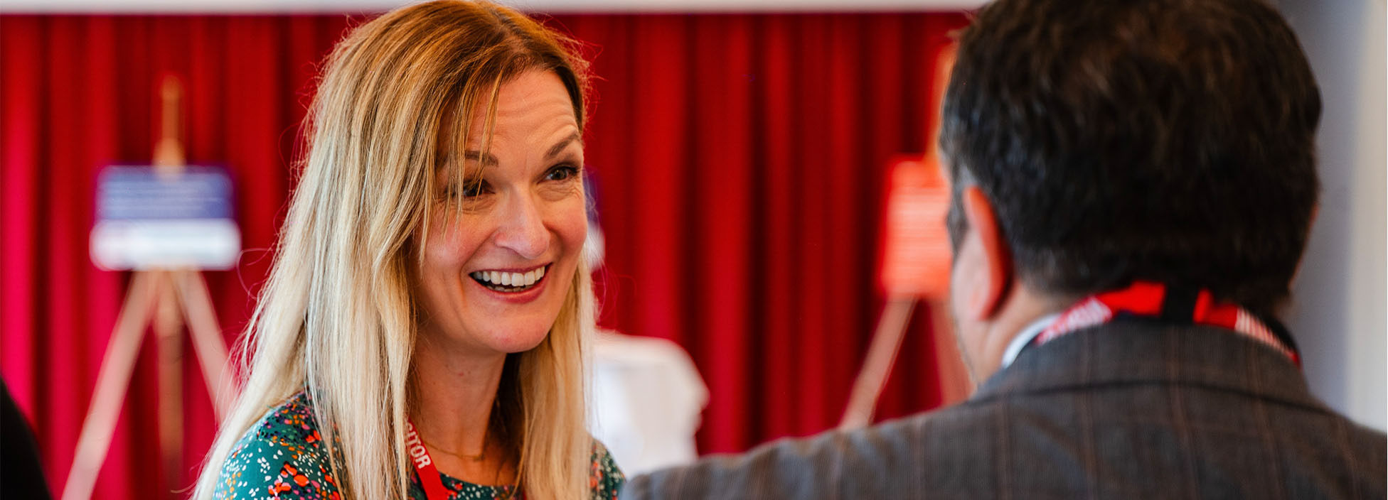 A woman smiling at a Fix The Digital Divide event with partners